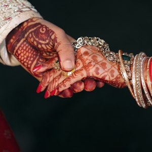 Bride and groom's hands with mehndi and bangles, symbolising love marriage astrology guidance